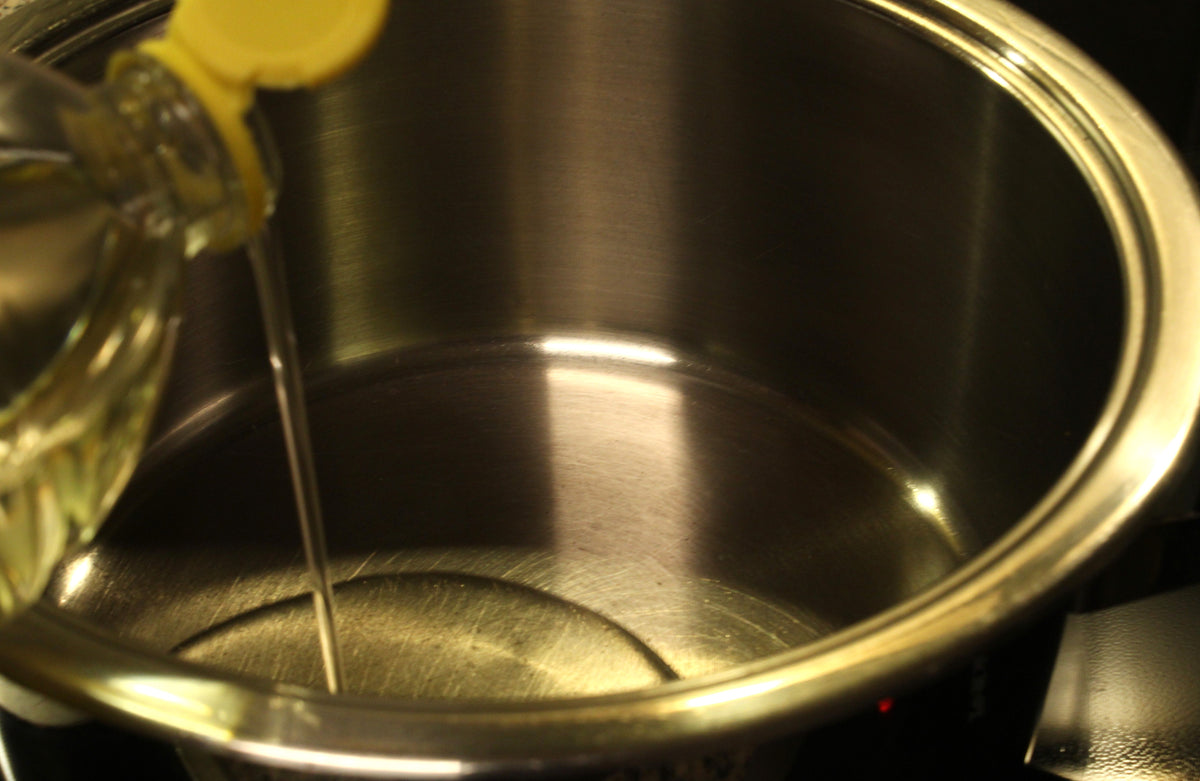 Öl wird zum Popcorn machen in einen Topf gegossen